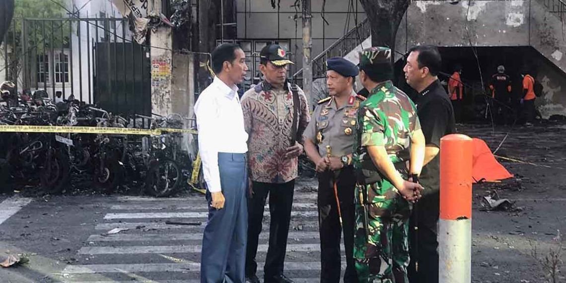 This handout photo released by Presidential Palace on May 13, 2018 shows Indonesia's President Joko Widodo (L), National Police Chief Tito Karnavian (C), Coordinating Minister for Social, Political, Legal and Security Affairs Wiranto (2nd L), and Armed Forces Chief Hadi Tjahjanto (2nd R) at the scene of an attack outside the Central Pantekosta church (Gereja Pantekosta Pusat) in Surabaya.A series of blasts, including at least one suicide bombing, struck churches in Indonesia on Sunday, killing at least 11 people and wounding dozens in the deadliest attack for years in the world's biggest Muslim-majority country. / AFP PHOTO / INDONESIAN PRESIDENTIAL PALACE / Handout / RESTRICTED TO EDITORIAL USE - MANDATORY CREDIT "AFP PHOTO / PRESIDENTIAL PALACE" - NO MARKETING NO ADVERTISING CAMPAIGNS - DISTRIBUTED AS A SERVICE TO CLIENTS