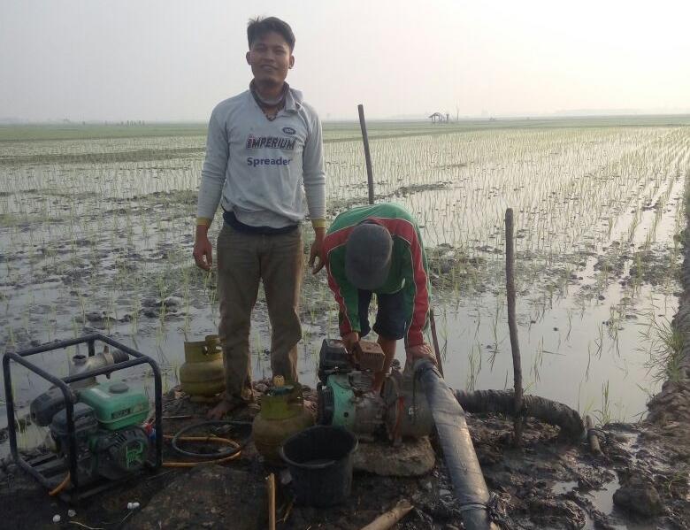 MODIFIKASI MESIN SEDOT AIR. Petani memodifikasi tabung gas elpiji sebagai bahan bakar mesin sedot air di areal sawah Desa Baliagung, Kecamatan Palas, Lampung Selatan, Kamis (9/8).n LAMPUNG POST/ARMANSYAH