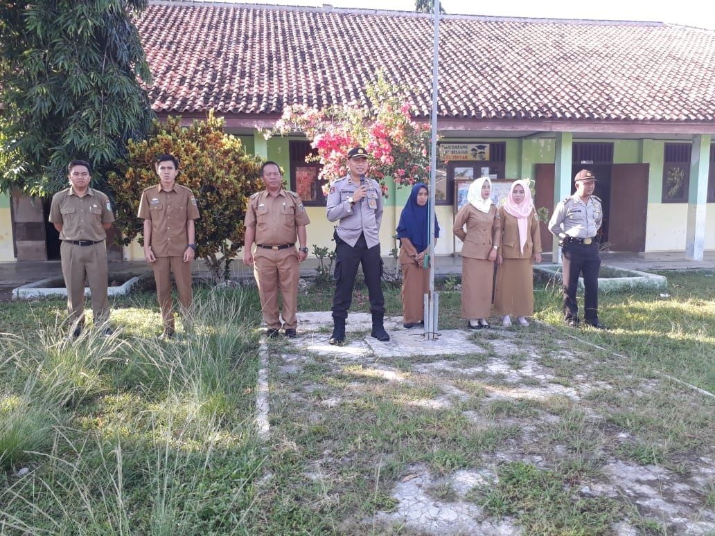 MOTIVASI SISWA. Kapolsek Bengkunat Iptu Ono Karyono memotivasi siswa untuk menjauhi kenakalan remaja. Siswa diminta menjadi duta antinarkoba dan tertib lalu lintas di sekolah setempat, Selasa (4/8). (LAMPUNG POST/DETA CITRAWAN)