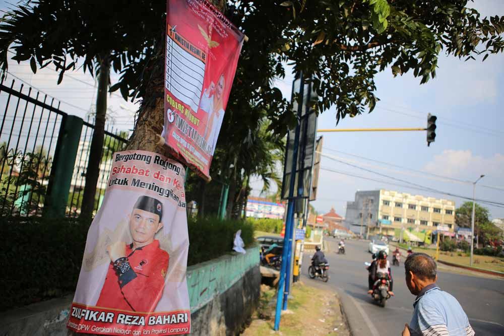 APK LANGGAR ATURAN. Warga melintas di dekat alat peraga kampanye yang dipasang di batang pohon di Jalan Dr Warsito, Bandar Lampung, Selasa (2/10). Pemasangan APK tersebut melanggar aturan yang ditentukan KPU Provinsi Lampung.
LAMPUNG POST/IKHSAN DWI NUR SATRIO