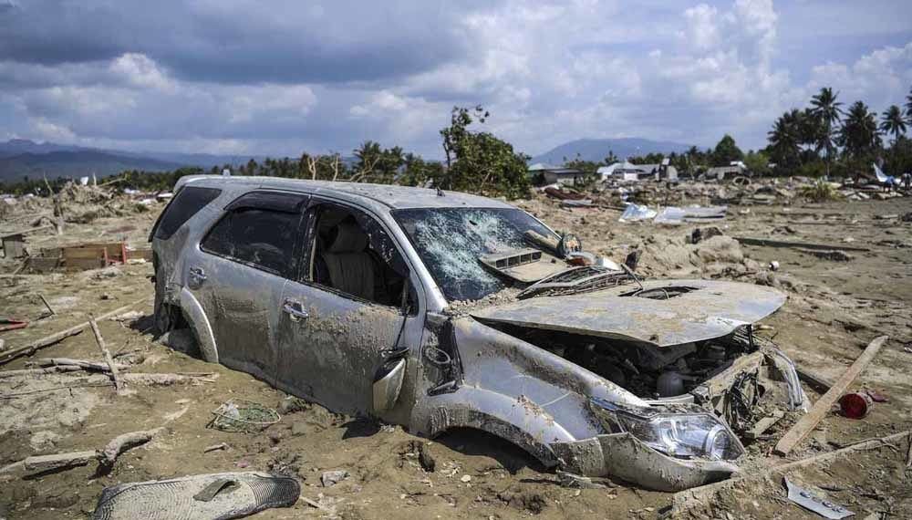 Sebuah mobil tertimbun lumpur akibat pencairan (likuifaksi) tanah yang terjadi di Desa Jono Oge, Sigi, Sulawesi Tengah, Kamis (4/10). Likuifaksi tanah yang terjadi akibat gempa berkuatan 7,4 skala richter di Palu-Donggala itu menyebabkan ratusan rumah hancur dan terkubur lumpur. ANTARA FOTO/Hafidz Mubarak A/foc/18.