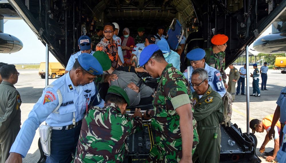 Personel TNI membawa korban luka bencana gempa dan tsunami Palu dan Donggala, Sulawesi Tengah setibanya di Base Ops Lanudal Juanda, Sidoarjo, Jawa Timur, Kamis (4/10). Korban luka akibat gempa dan tsunami Palu-Donggala tersebut mendapatkan perawatan di RSUD Terdekat. ANTARA FOTO/Umarul Faruq/foc/18.