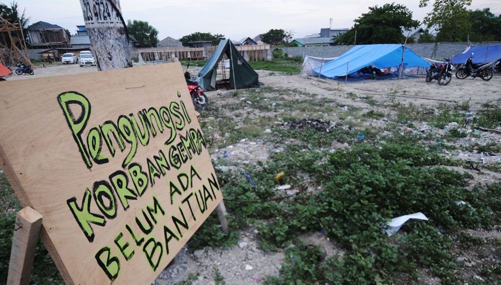 Pengungsi memasang tanda belum mendapat bantuan di salah satu titik pengungsian di Kelurahan Palupi Palu, Sulawesi Tengah, Kamis (4/10). Posko Satgab Penanggulangan Bencana merilis, jumlah pengungsi yang terdata mencapai 70.821 orang. ANTARA FOTO/Basri Marzuki/foc/18.