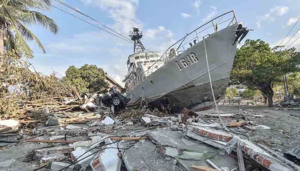 Warga berada di dekat kapal TNI AL yang terdampar di jalanan akibat tsunami di Watusampu, Ulujadi, Palu, Sulawesi Tengah, Kamis (4/10).  ANTARA FOTO/Muhammad Adimaja/ama/18