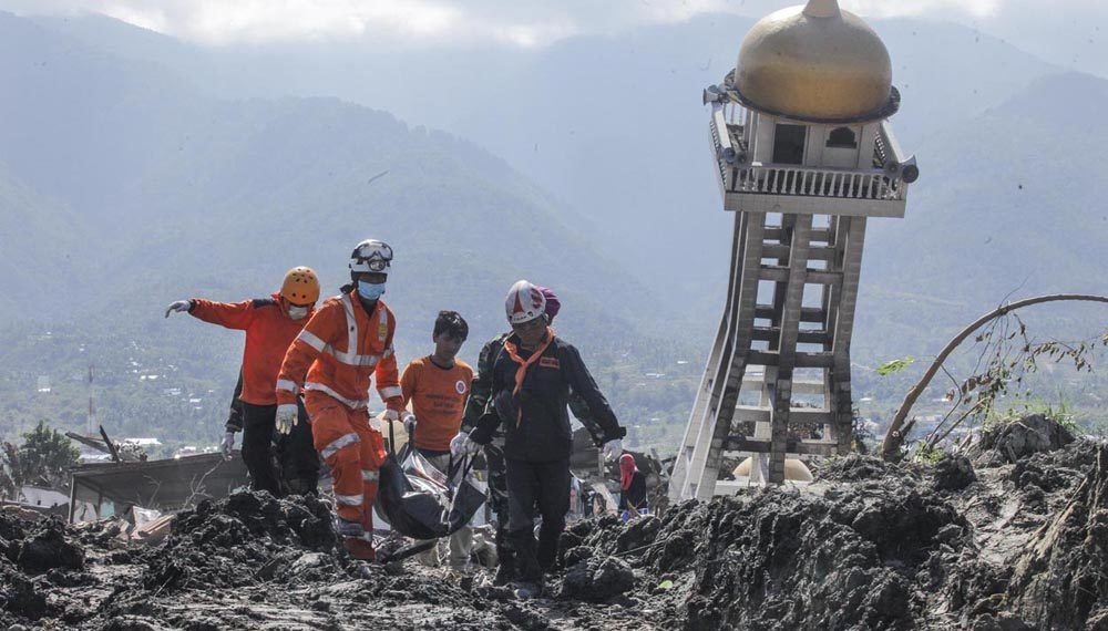 Anggota Basarnas bersama TNI dan relawan membawa kantong berisi jenazah korban gempa dan tsunami di Balaroa, Palu, Sulawesi Tengah, Kamis (4/10). Basarnas bersama TNI dan relawan menggunakan alat berat terus melakukan pencarian serta evakuasi jenazah di wilayah tersebut. ANTARA FOTO/Muhammad Adimaja/ama/18