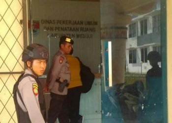 KPK. Sejumlah anggota polisi berjaga di depan kantor Dinas PU-Pera Mesuji yang diduga didatangi tim KPK, Selasa (29/1). n LAMPUNG POST/IST