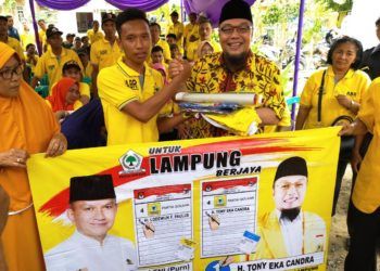 SERAHKAN APK. Calon anggota DPRD Lampung DP Lampung Selatan nomor urut 1 Partai Golkar Tony Eka Candra menyerahkan alat peraga kampanye kepada seorang sukarelawan di Kecamatan Tanjungsari, Lampung Selatan, Selasa (5/2). n LAMPUNG POST/DOK GOLKAR