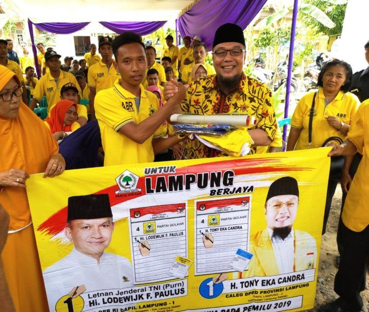 SERAHKAN APK. Calon anggota DPRD Lampung DP Lampung Selatan nomor urut 1 Partai Golkar Tony Eka Candra menyerahkan alat peraga kampanye kepada seorang sukarelawan di Kecamatan Tanjungsari, Lampung Selatan, Selasa (5/2). n LAMPUNG POST/DOK GOLKAR