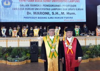 PENGUKUHAN GURU BESAR. Rektor Unila Hasriadi Mat Akin (kiri) mengukuhkan Maroni sebagai guru besar bidang Ilmu Hukum Pidana, di GSG Unila, Rabu (13/2). Maroni adalah guru besar ke-67 di Unila. (LAMPUNG POST/TRIYADI ISWORO)