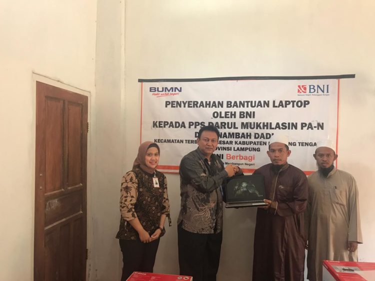 SERAHKAN BANTUAN. Pimpinan BNI Cabang Metro Mus Adral (dua kiri), didampingi Pimpinan BNI Cabang Bandarjaya Rini Wulandari, menyerahkan bantuan kepada pimpinan Pondok Pesantren Salafiah Darul Mukhlasun PS-N Miftakhul Maarif, di Desa Nambahdadi, Terbanggibesar, Lampung Tengah, Kamis (14/3).DOK. BNI