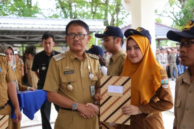 Bupati Pesisir Barat Agus Istiqlal, secara simbolis menyerahkan Surat Keputusan (SK) tenaga kontrak kepada para Pegawai yang dikontrak pemkab pesisir barat , di halaman Kantor bupati, Selasa (12/3). Dok Humas