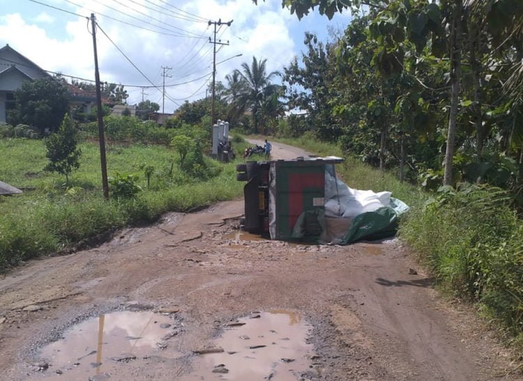 Jalan Rusak Membuat Truk Pengangkut Terigu Terguling