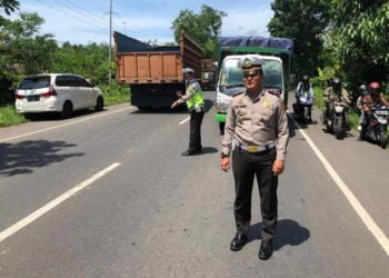 ATUR LALU LINTAS. Kasat Lantas Polres Lampung Selatan, AKP Reza Khomeini saat mengatur lalu lintas di Jalinsum, beberapa waktu lalu. (DOKUMENTASI Lantas POLRES LAMSEL)