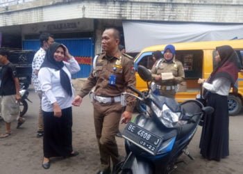RAZIA. Petugas Satpol PP Lampung Utara menjaring sejumlah aparatur sipil negara (ASN) dan pelajar di Pasar Dekon Kotabumi, Rabu (15/5). (LAMPUNG POST/FAJAR NOFITRA)
