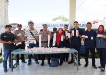BORAKS. Kapolsek Banjaragung Kompol Rahmin dan Kepala Loka POM Tulangbawang Tuti Nurhayati menunjukkan boraks yang disita dari pedagang, Kamis (16/5). Barang berbahaya tersebut disita saat menggelar razia di Pasar Unit II Banjaragung. (LAMPUNG POST/FERDI IRWANDA)