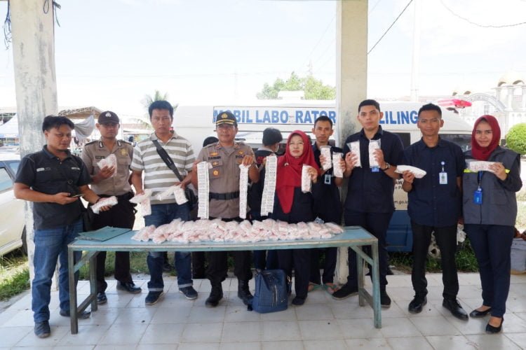 BORAKS. Kapolsek Banjaragung Kompol Rahmin dan Kepala Loka POM Tulangbawang Tuti Nurhayati menunjukkan boraks yang disita dari pedagang, Kamis (16/5). Barang berbahaya tersebut disita saat menggelar razia di Pasar Unit II Banjaragung. (LAMPUNG POST/FERDI IRWANDA)