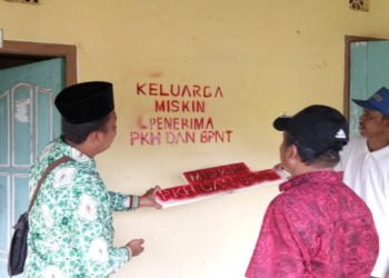 TANDA KHUSUS. Proses pemasangan tanda khusus bagi KPM bantuan PKH di Desa Palasaji, Kecamatan Palas, Lampung Selatan, Kamis (16/5). Pemasangan tanda khusus tersebut untuk transparansi terhadap penerima bantuan PKH. (LAMPUNG POST/ARMANSYAH)