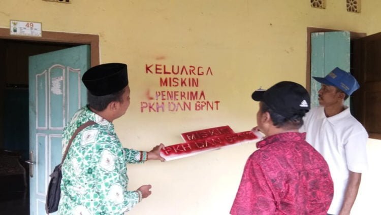 TANDA KHUSUS. Proses pemasangan tanda khusus bagi KPM bantuan PKH di Desa Palasaji, Kecamatan Palas, Lampung Selatan, Kamis (16/5). Pemasangan tanda khusus tersebut untuk transparansi terhadap penerima bantuan PKH. (LAMPUNG POST/ARMANSYAH)