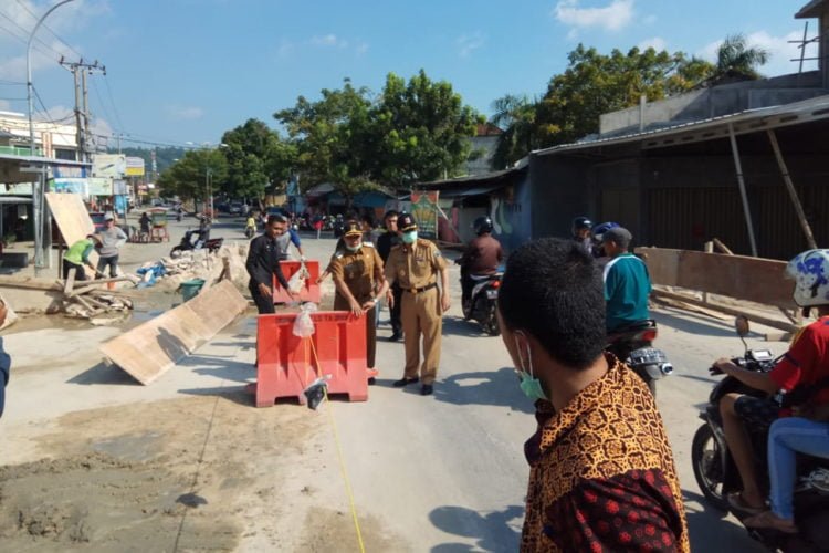 BISA DILALUI. Plt Bupati Lampung Selatan Nanang Ermanto dan Sekkab Fredy SM menggeser penghalang jalan sebagai tanda jembatan pasar Inpres Kalianda bisa dilalui kendaraan roda empat, Senin (27/5). Kendaraan yang boleh lewat selain sepeda motor adalah kendaraan roda empat. (LAMPUNG POST/JUWANTORO)