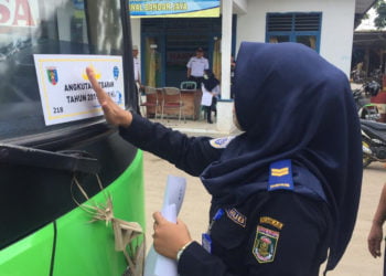 STIKER LAIK. Seorang petugas menempelkan striker laik bagi bus angkutan mudik di Terminal Bandarjaya, beberapa waktu lalu. Dari 70 bus hanay 30 yang layak mengangkut penumpang mudik. (DOKUMENTASI DINAS PERHUBUNGAN LAMTENG)