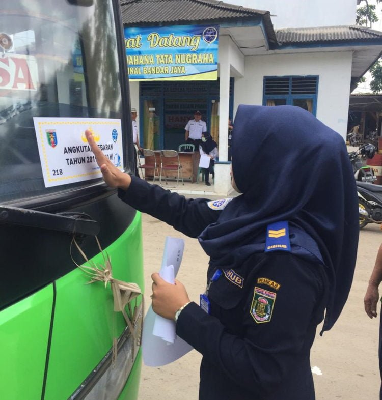 STIKER LAIK. Seorang petugas menempelkan striker laik bagi bus angkutan mudik di Terminal Bandarjaya, beberapa waktu lalu. Dari 70 bus hanay 30 yang layak mengangkut penumpang mudik. (DOKUMENTASI DINAS PERHUBUNGAN LAMTENG)