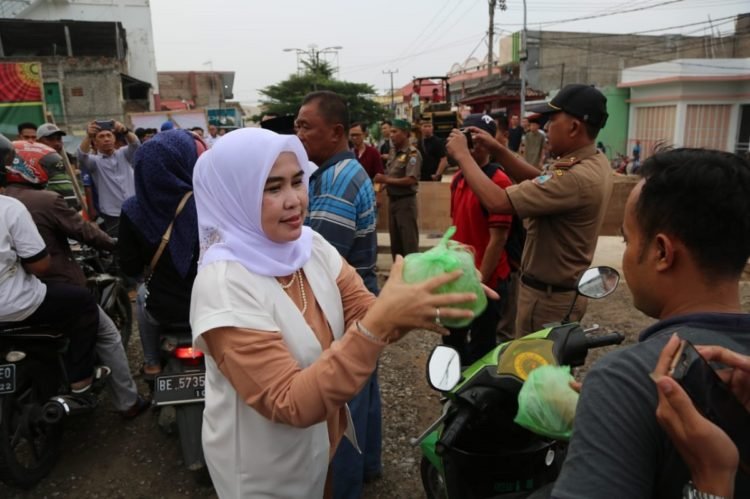 BAGIKAN TAKJIL. Ketua TP PKK Lampung Selatan Winarni Nanang Ermanto membeli dan membagikan takjil kepada masyarakat, Senin (20/5). Winarni Nanang Ermanto membeli takjil yang dijual masyarakat di sepanjang jalan protokol Kota Kalianda.(DOK. DISKOMINFO LAMPUNG SELATAN)