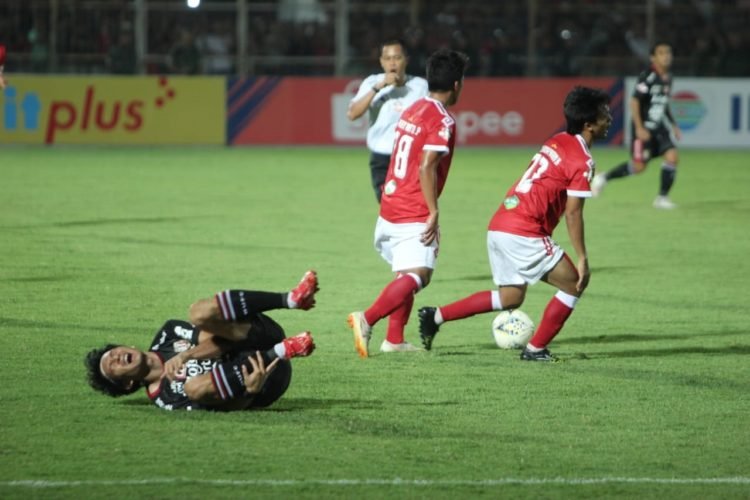 TERSUNGKUR. Pemain Bali United M Orah tersungkur setelah dilanggar dua pemain Badak Lampung FC dalam lanjutan Liga 1 2019 di Stadion Sumpah Pemuda Way Halim Bandar Lampung, Minggu (30/6). Pada pertandingan tersebut Badak Lampung FC kalah 0-3 dari Bali United.
(LAMPUNG POST/SUKISNO)