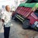 SERUDUK KIOS. Dump truck bermuatan kopi yang menabrak kios dan seorang warga di Jalan Ahmad Yani, Gedongtataan, Pesawaran, Jumat (21/6). Kecelakaan tersebut mengakibatkan satu orang mengalami luka parah. (LAMPUNG POST/AHMAD AMRI)