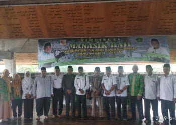 MANASIK. Asisten II Pemerintah Kabupaten Tulangbawang Barat Syakib Arsalan berfoto bersama sejumlah jemaah calon haji yang mengikuti manasik di Gedung Sesat Agung Bumi Gayo, Panaraganjaya, Tulangbawang Tengah, Rabu (19/6). (LAMPUNG POST/AHMAD SOBIRIN)