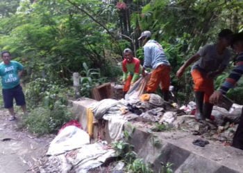 BERSIHKAN SAMPAH. Petugas kebersihan Dinas Lingkungan Hidup Lampung Barat membersihkan tumpukan sampah yang dibuang masyarakat secara sembarangan di jalan perlintasn. Dinas LH mengerahkan sejumlah armada dan personal. (DOKUMENTASI DLH LAMBAR)