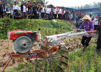 COBA TRAKTOR TANGAN. Bupati Lampung Barat Parosil Mabsus mencoba traktor tangan saat penyerahan bantuan sarana pertanian kepada kelompok tani di Pekon Buay Nyerupa, Kecamatan Sukau, Rabu (31/7). Bantuan yang disalurkan Pemkab diharapkan dapat meningkatkan kesejahteraan petani. (DOKUMENTASI HUMAS PEMKAB LAMBAR)