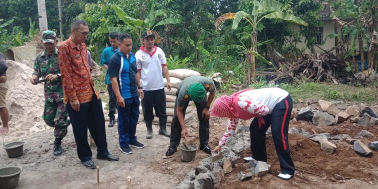 BEDAH RUMAH. Camat Palas, Lampung Selatan, Rika Wati bersama Uspika dan didampingi Pjs Kepala Desa Sukaraja Ridwan secara simbolis  melakukan peletakan batu program bedah rumah di Dusun Simpangpelabuh, Desa Sukaraja, Jumat (18/7). Pemerintah desa setempat melakukan bedah rumah untuk tujuh kepala keluarga. (LAMPUNG POST/ARMANSYAH)