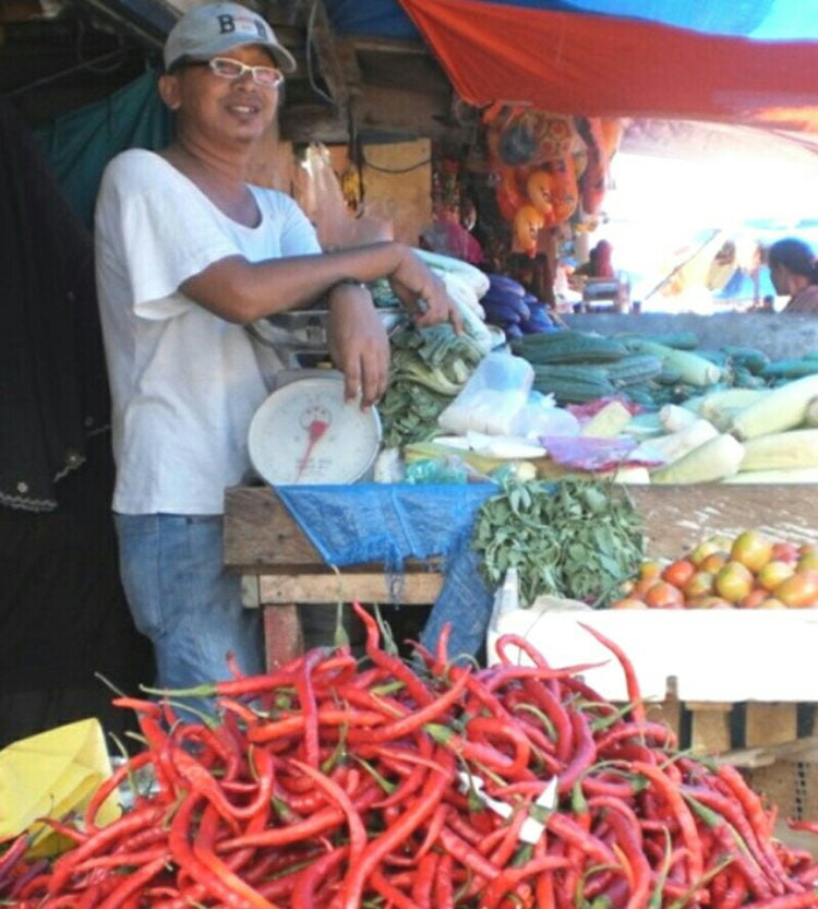 TERUS NAIK. Seorang pedagang sayur-mayur menunggui cabai dagangannya, Minggu (7/7). Harga cabai di sejumlah pasar di Lampung Selatan terus naik menjadi Rp70 ribu per kg. (LAMPUNG POST/AAN KRIDOLAKSONO)
