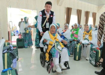 GUNAKAN KURSI RODA. Seorang calon haji (calhaj) dari Kabupaten Lampung Utara yang tergabung dalam kloter 47 didorong menggunakan kursi roda oleh petugas saat tiba di Asrama Haji Rajabasa, Bandar Lampung, Kamis (11/7).
(LAMPUNG POST/IKHSAN DWI NUR SATRIO)