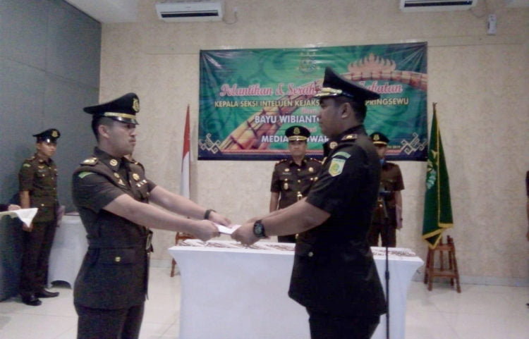 SERTIJAB. Mantan Kasi Intelijen Kejari Pringsewu Bayu Wibianto (kanan) menyerahkan tugas dan tanggung jawab kepada Kasi Intelijen Kejari Pringsewu yang baru Median Suwardi (kiri) disaksikan Kejari setempat Asep Sontani Sunarya pada pelantikan dan serah terima jabatan di Hotel Urban Pringsewu, Senin (15/7). (LAMPUNG POST/WIDODO)