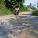 BELUM DIPERBAIKI. Kerusakan jalan poros Desa Kemukus, Kecamatan Ketapang, Lampung Selatan, yang sudah cukup lama mengganggu perekonomian masyarakat setempat. Tampak kerusakan jalan yang dibidik Rabu (31/7). (LAMPUNG POST/AAN KRIDOLAKSONO)