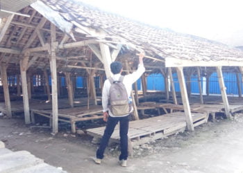 NYARIS AMBRUK. Salah satu warga saat melihat kondisi los pasar tradisional Desa Bumidaya, Kecamatan Palas, Lampung Selatan, yang kondisinya memprihatinkan, Rabu (24/7). Tiang los sudah miring dan kayunya sudah lapuk. (LAMPUNG POST/ARMANSYAH)