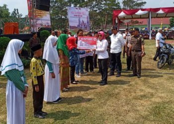 MAKANAN BERGIZI. Bupati Winarni secara simbolis memberikan makanan tambahan anak sekolah (PMTAS) bagi siswa sekolah dasar dan madrasah ibtidaiah se-Tulangbawang di Lapangan Setiamuda, Kampung Penawarrejo, Kecamatan Banjarmargo, Rabu (31/7). Makanan bergizi berpengaruh terhadap kualitas sumber daya manusia pada masa mendatang. (DOKUMENTASI HUMAS PEMKAB TUBA)