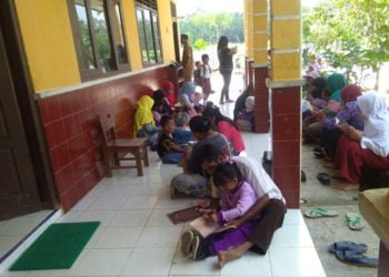 AJAK ORANG TUA. Peringati Hari Anak Nasional 2019, penggiat literasi Motor Pustaka Lampung Selatan mengajak orang tua membaca buku untuk anaknya. Sejumlah ibu dan anak bersama-sama membaca buku di SDN 1 dan TK PGRI Desa Pasuruan, Kecamatan Penengahan, Selasa (23/7).  (LAMPUNG POST/AAN KRIDOLAKSONO)