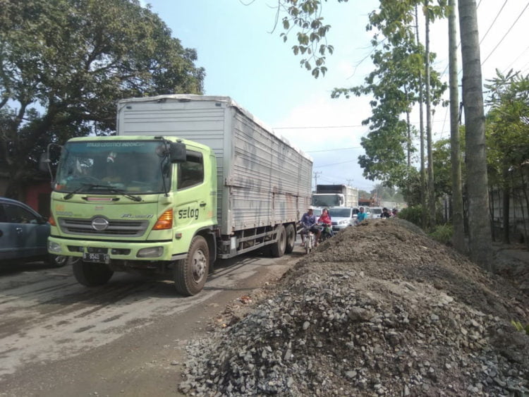 MACET. Perbaikan gorong-gorong di Jalinsum Km 21-22 Desa Tarahan, Kecamatan Katibung, Lampung Selatan, menimbulkan kemacetan, Senin (29/7). (LAMPUNG POST/PERDHANA WIBYSONO)