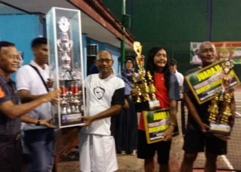 SERAHKAN PIALA. Wali Kota Metro Achmad Pairin menyerahkan piala bergilir dan tetap turnamen tenis lapangan Wali Kota Cup II Kota Metro 2019 di Lapangan AB, Minggu (28/7) malam. (LAMPUNG POST/SUPRAYOGI)