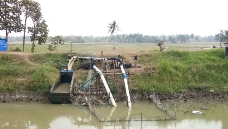 SEDOT AIR. Mesin pompa milik petani di Palas, Lampung Selatan, menyedot air dari sungai untuk mengairi lahan sawah saat memasuki musim tanam gaduh. Mereka butuh air untuk melakukan awal pengolahan lahan dengan bajak. (LAMPUNG POST/ARMANSYAH)