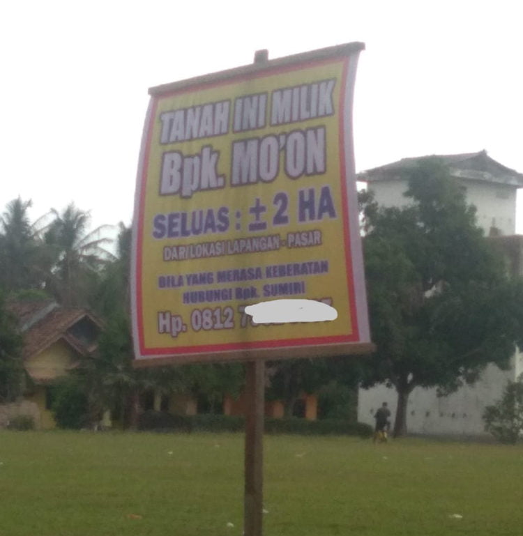 SENGKETA. Banner penyegelan oleh warga bernama Mo’on atas lahan lapangan sepak bola dan pasar tradisional Desa Bumidaya, Kecamatan Palas, Lampung Selatan, Senin (8/7). Padahal, pemerintah desa setempat memiliki surat keabsahan atas tanah tersebut. (LAMPUNG POST/ARMANSYAH)