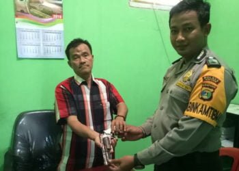 SERAHKAN SENPI RAKITAN. Kepala Kampung Binabumi, Kecamatan Meraksaaji, Tulangbawang, Sudarjo menyerahkan senpi rakitan kepada Bhabinkamtibmas setempat Brigpol Wahyu Eko Budi Wahyono, di rumahnya, Jumat (12/7).
(LAMPUNG POST/FERDI IRWANDA)
