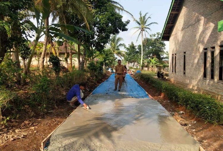 JALAN BETON. Pembangunan jalan rabat beton di Dusun I, Desa Sidorejo, Kecamatan Sidomulyo, Lampung Selatan. (LAMPUNG POST/PERDHANA WIBYSONO)