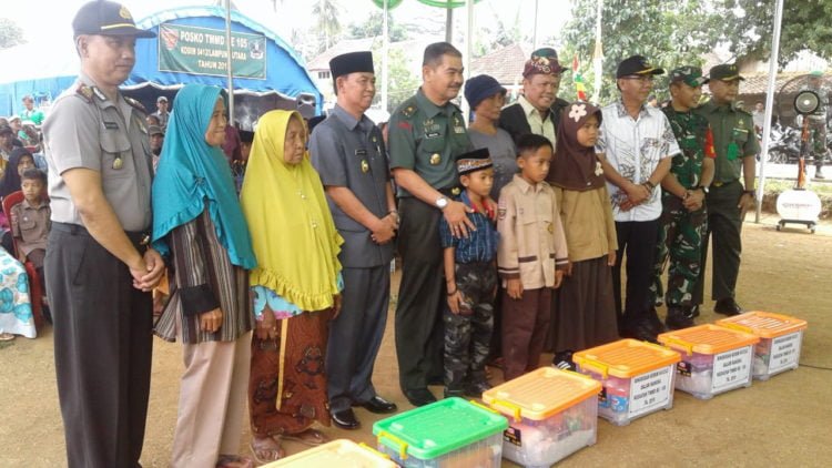 BANTUAN SOSIAL. Ketua Tim Wasev TMMD, Brigjen TNI Amalsyah Tarmizi mendampingi Wakil Bupati Lampung Utara, Budi Utomo, berfoto bersama usai penyerahan secara simbolis bantuan sosial bagi janda dan anak yatim saat meninjau pelaksanaan kegiatan TMMD ke-105 Kodim 0412/LU di lapangan Desa Batunangkop, Kecamatan Sungkai Tengah, Sabtu (20/7). (LAMPUNG POST/YUDHI HARDIYANTO)