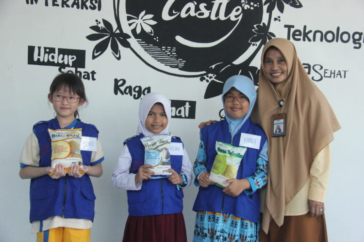 Reporter cilik Lampung Post mendengarkan penjelasan dari Program Director Technopark Lampung Tengah Banon Rustiaty sambil menikmati bubur ayam yang terbuat dari beras yang berasal dari singkong.