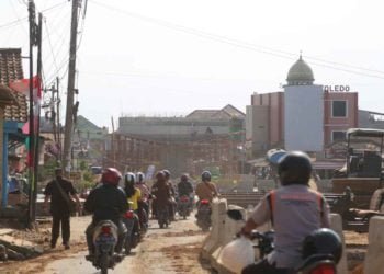 PROYEK FLYOVER. Pengendara motor melintas di dekat pembangunan proyek di Jalan Untung Suropati-RA Basyid Bandar Lampung, Senin (5/8). Pengerjaan proyek tersebut terus dikebut dan ditargetkan selesai akhir tahun.
n LAMPUNG POST/IKHSAN DWI NUR SATRIO