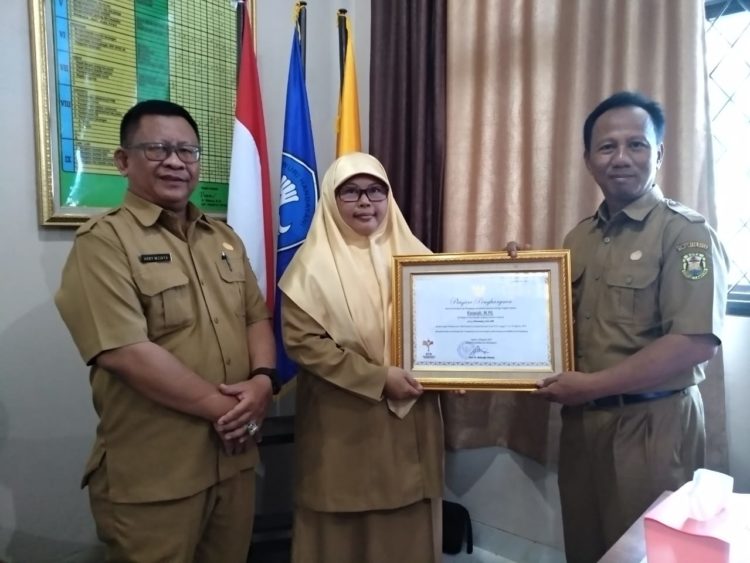 JUARA NASIONAL. Guru berprestasi tingkat nasional, Khoiriah berfoto bersama  Pengawas SMPN 32 Bandar Lampung Heri (kiri) dan Kepala Sekolah SMPN 32 Bandar Lampung Wahono (kanan), Senin (26/8) (LAMPUNG POST/FEBI HERUMANIKA)