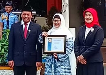 : SERAHKAN PENGHARGAAN Kasubdit Abdimas dan KKN UBL, Putri Suryandari ST MArs (tengah), menerima penghargaan dari Kepala LL-Dikti Wilayah III Dr Illah Sailah, Selasa (20/8).  Kampus UBL dinilai berkontribusi nyata melibatkan masyarakat penggiat sampah se-Jabotabek dalam mengolah sampah saset minuman menjadi permadani terbesar di dunia. (Istimewa)